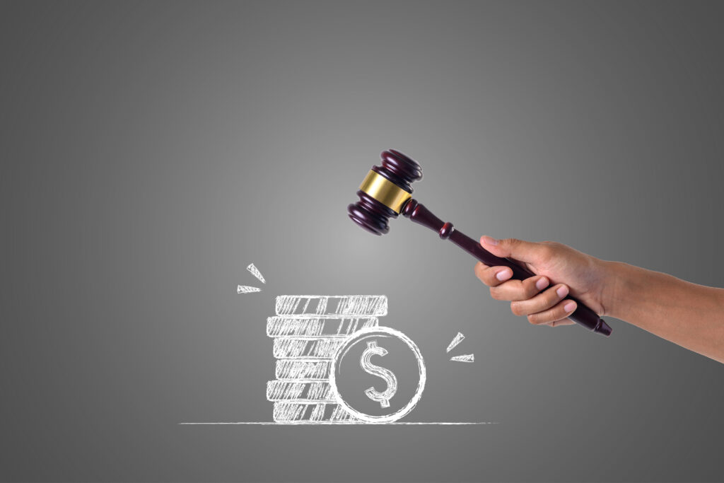 hand that holds hammer piles money written with white chalk draw concept